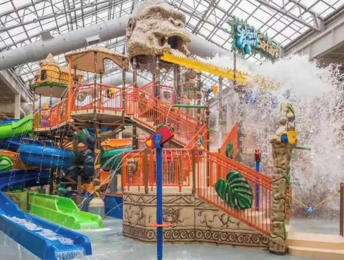 An indoor water park with slides, a climbing structure, and a splash zone.