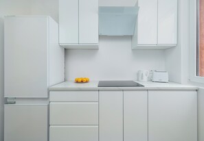 Eine moderne Küche mit weißen Schränken, einer Arbeitsplatte, einem Toaster und einer Zitronenschale.