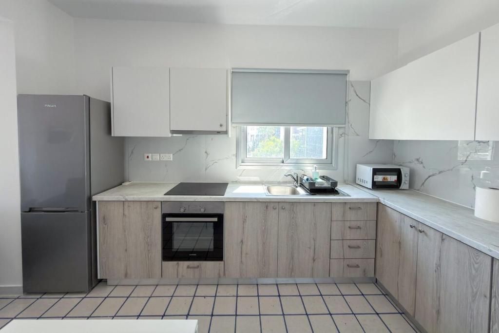 Una cocina moderna con horno empotrado, microondas y refrigerador.