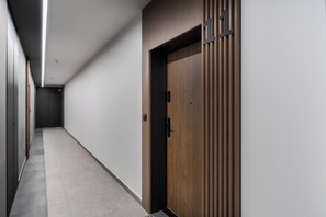 Ein Flur mit einer Holztür und einem Lichtschalter an der Wand.