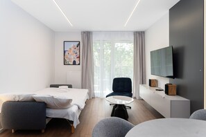 Ett modernt hotellrum med en säng, en sittgrupp och en TV.