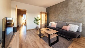 Een moderne woonkamer met een bank, een salontafel en een televisie.