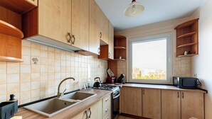 Eine Küche mit Holzausstattung, einem Spülbecken, einem Herd und einem Fenster mit Blick.