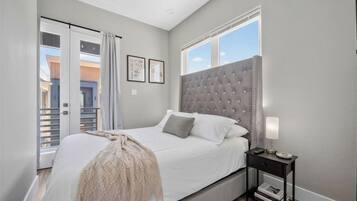 Bright modern bedroom with tufted headboard and private balcony access
