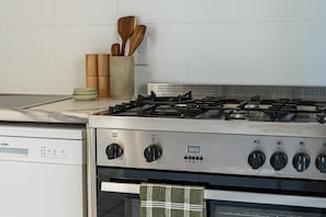 A kitchen with a gas stove, oven, and a dishwashing unit. - The Palms - private yard & parking, 200m to beach (Margate)