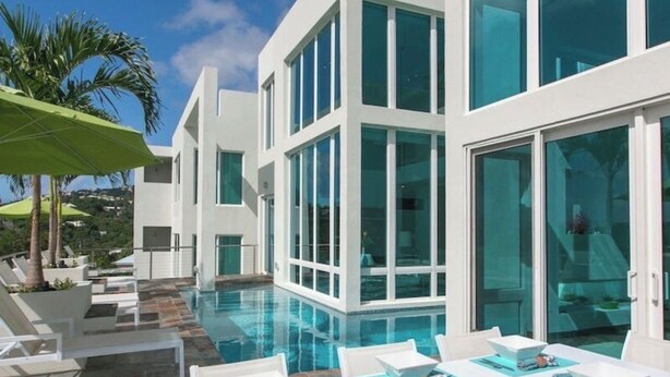 A modern hotel with a pool area, outdoor seating, and large windows. - NEW! Dreamy & Spacious 5-bedroom house with generator in Cruz Bay with Pool (Cruz Bay)