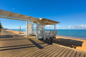 A wooden boardwalk leading to a beach with a covered seating area. - Margate Beach Studio 4 (Margate)
