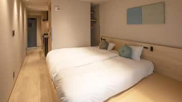 A hotel room with a large bed, a wardrobe, and a painting on the wall.