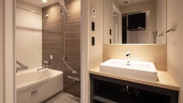 A modern bathroom with a bathtub, a shower, and a vanity with a sink.