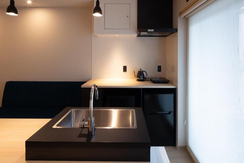 A modern kitchen with a built-in sink, a black countertop, and a black cabinet above the sink.