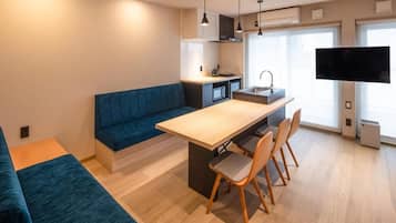 Una cocina moderna con comedor, sofá integrado y televisor de pantalla plana.