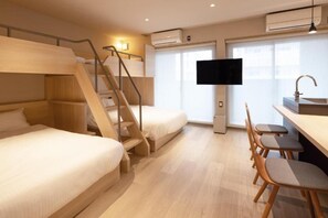 A hotel room with bunk beds, a desk with chairs, a television, and a window. - ALPHABED INN Hakata station front (fukuokashi hakataku hakataekimae)