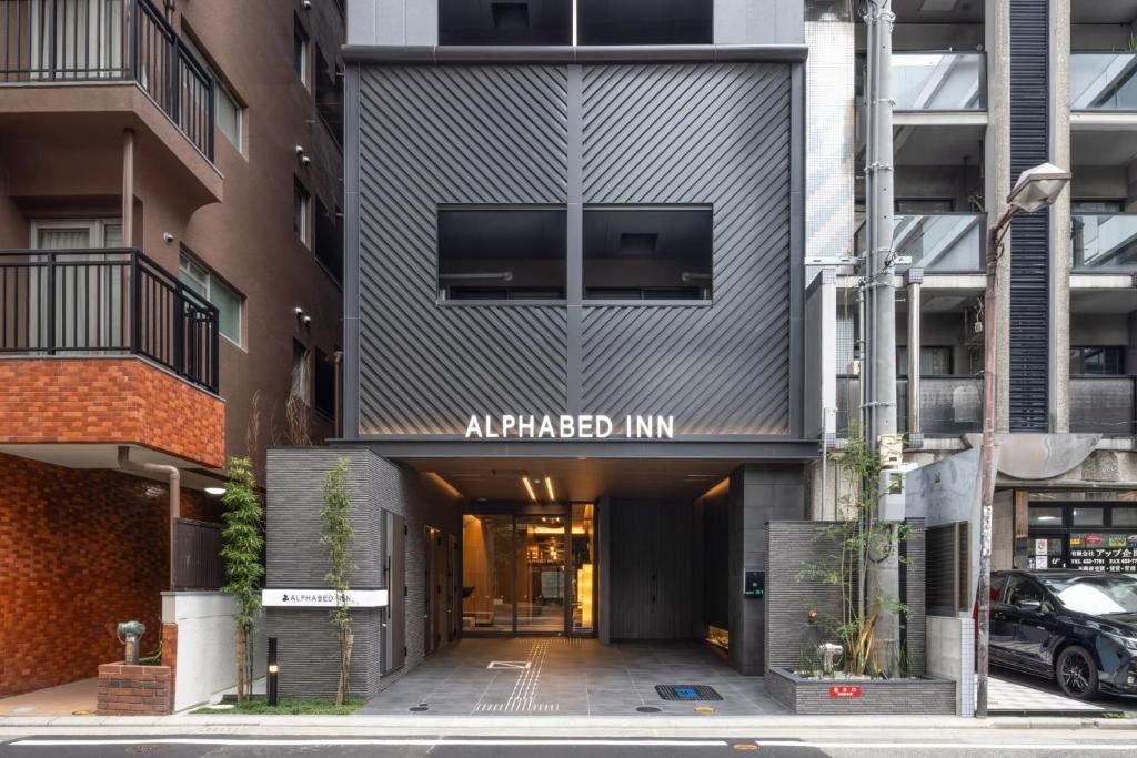 Een modern gebouw met het bord 'ALPHABED INN', dat een hotel aangeeft.