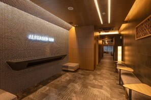 A modern interior with a textured wall, a bench, and a seating area. - ALPHABED INN Hakata station front (fukuokashi hakataku hakataekimae)