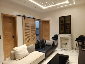 A modern living room with a sofa, a coffee table, and a fireplace. - Your Home Away From Home – Comfort, Peace & Warm Hospitality (Lagos)
