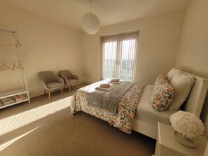 A bedroom with a bed, two chairs, a wardrobe, and a window with blinds. - Sheffield 2-Bed Penthouse Apt, Sleeps 4 w/ Balcony (Sheffield)