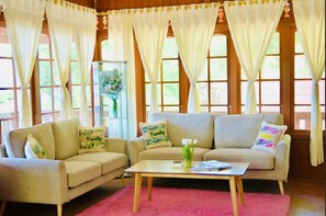 A cozy living room with two sofas, a coffee table, and a vase of flowers.