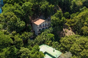 Ein zweistöckiges Haus, umgeben von dichtem Wald.