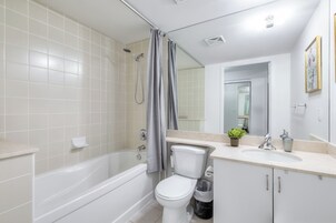 Een moderne badkamer met bad, toilet en wastafel.