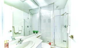 Ein modernes Badezimmer mit einer einteiligen Duschkabine, einem weißen Waschbecken und einer Toilette.