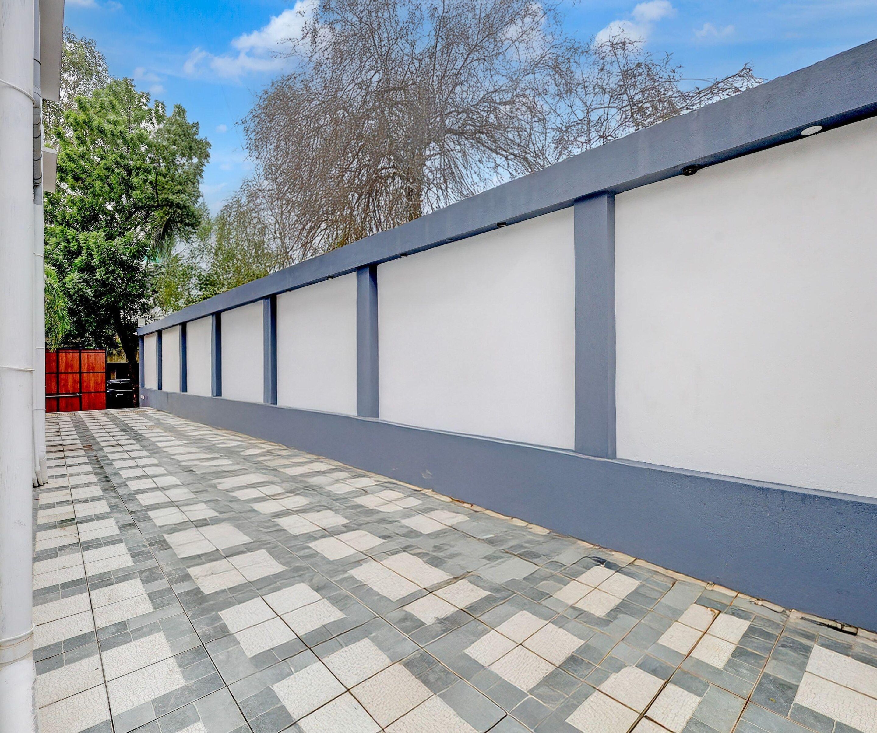 A corridor with a tiled floor and a white wall with blue trim.