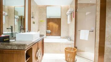 A modern bathroom with a large mirror, a vanity with a sink, a shower area, and a toilet.