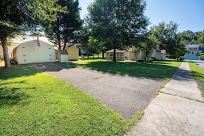 Un barrio residencial con un camino pavimentado, césped y varias casas.
