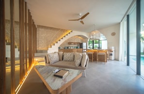 Ein modernes Wohnzimmer mit einer Couch, einem Couchtisch und einer Treppe mit Holzwangen.