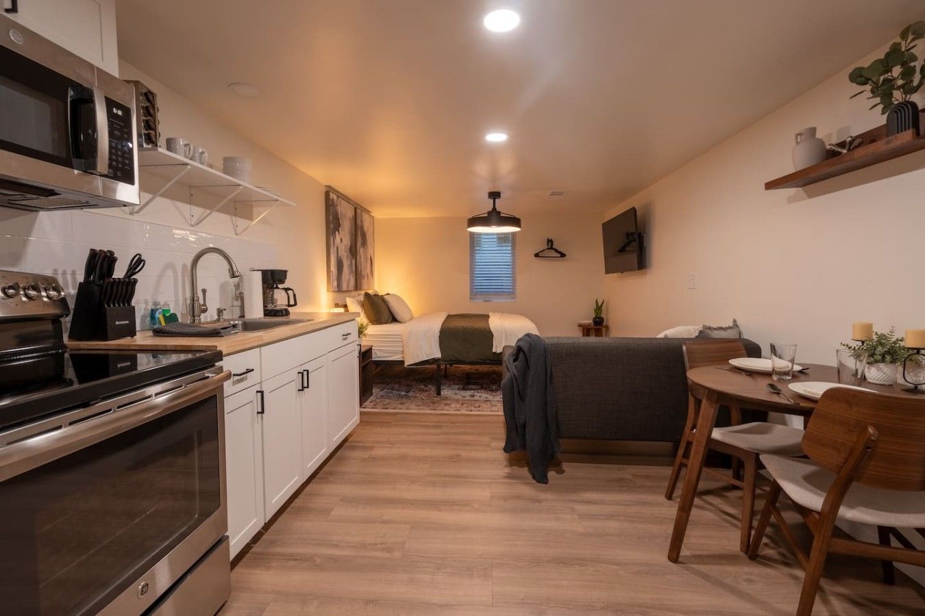 A compact living space with a kitchenette, a dining area, and a bed.