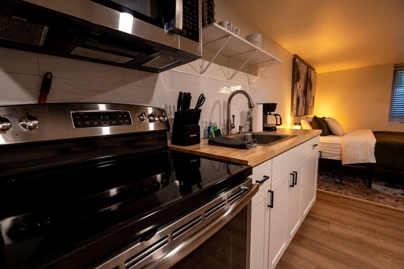 A modern kitchen with a stainless steel stove, a sink, and a coffee maker.