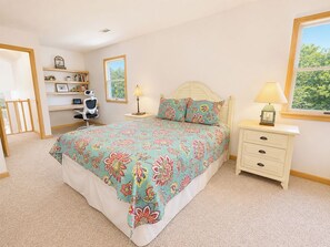 A bedroom with a bed, bedside tables, a chair, and a bookshelf. - Hidden Treasure -3 BR Home with Private Pool & Hot Tub (Southern Shores)