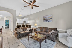A living room with a ceiling fan, two sofas, a coffee table, and a dining area with chairs. - 3BR/2BA Bahama Bay Pause in Davenport | Water View, Near Disney (Davenport)