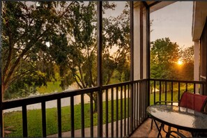 A covered outdoor area with a table and chairs, overlooking a body of water and trees. - 3BR/2BA Bahama Bay Pause in Davenport | Water View, Near Disney (Davenport)