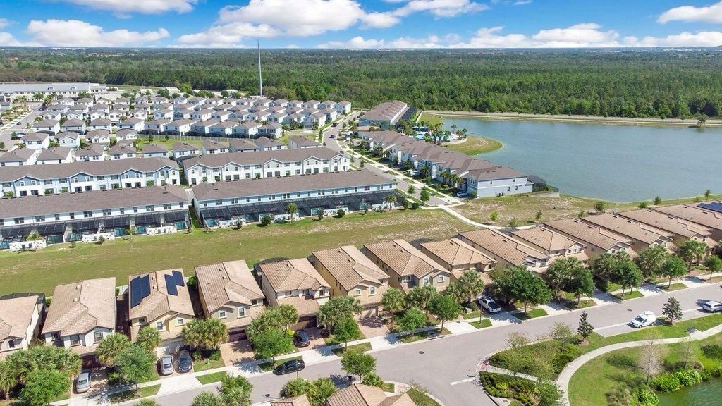 Zona residencial con varios edificios de apartamentos, un estacionamiento y una masa de agua.