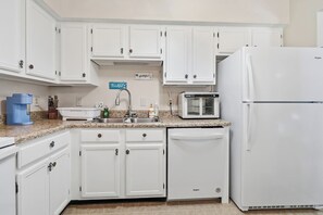 A kitchen with white cabinets, a sink, a toaster, and a refrigerator. - Family 4BR Home | Fenced Yard | 5 Min to Beach (Jacksonville)