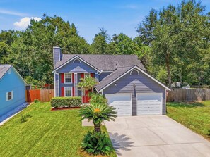 A residential house with a garage, a lawn, and a small tree in the front yard. - Serene Retreat w/ Private Backyard (Jacksonville)