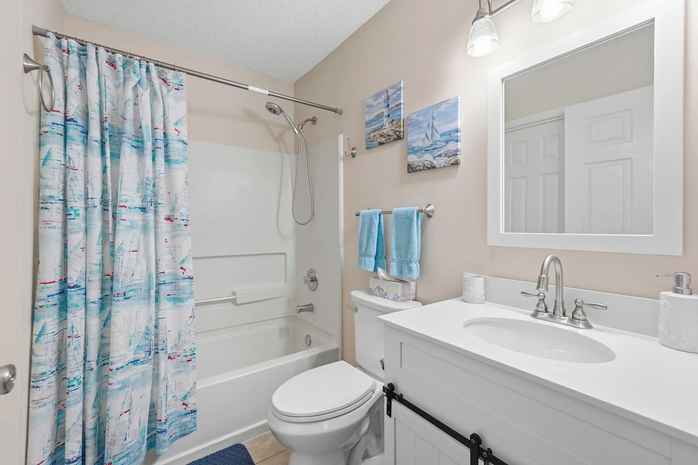 A bathroom with a shower, toilet, sink, and a mirror.