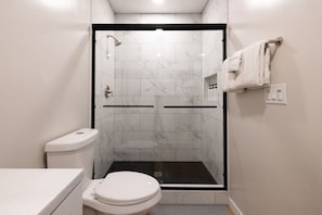 Ein modernes Badezimmer mit einer Duschkabine, einer Toilette und einem Waschbecken.