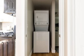 A laundry room with a washer and dryer, a stove, and a cabinet. - Cozy Casa | Sunny Santee Sanctuary (Santee)
