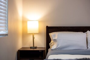 A bed with white linens and a nightstand with a lamp. - Cozy Casa | Sunny Santee Sanctuary (Santee)