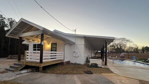 A single-story house with a covered porch, a small front yard, and a swimming pool. - Cozy 2-bedroom house in Bowdon (Bowdon)