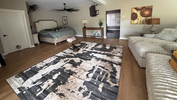 A bedroom with a bed, a ceiling fan, a rug, and a painting on the wall. - Cozy 2-bedroom house in Bowdon (Bowdon)