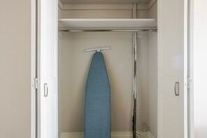 Ein Schrank mit Kleiderstange und einer Tür mit silbernem Griff.