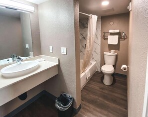 A bathroom with a sink, mirror, toilet, and shower. - Budget & Pet-Friendly Room | California State Railroad Museum - 2.6 Miles Away (West Sacramento)