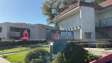 A building with a sign indicating a motel and studio, a staircase, and a clear sky.