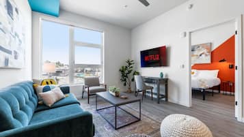 Una sala de estar moderna con un sofá, una mesa de centro y un televisor montado en la pared.