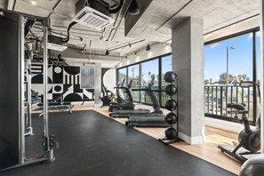 A modern gym with exercise equipment, large windows, and a view of the city. - The DTLA Haven, 1Mi to Dodger Stadium, Free Parking (Los Angeles)