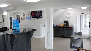 Una cocina moderna con una cafetera, un televisor montado en la pared y una encimera con un código QR.