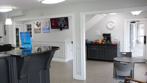 Una cocina moderna con una cafetera, un televisor montado en la pared y una encimera con un código QR.