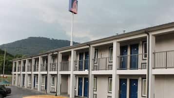 A motel with multiple floors, balconies, and a flag.